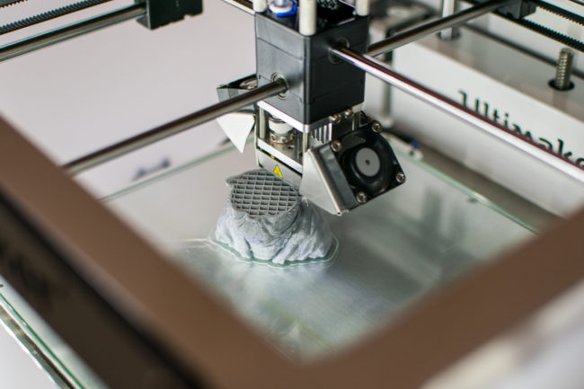 Imprimante 3D en cours d’impression d’un Yoda en résine grise au Fab Lab de la Casemate de Grenoble Imprimante 3D